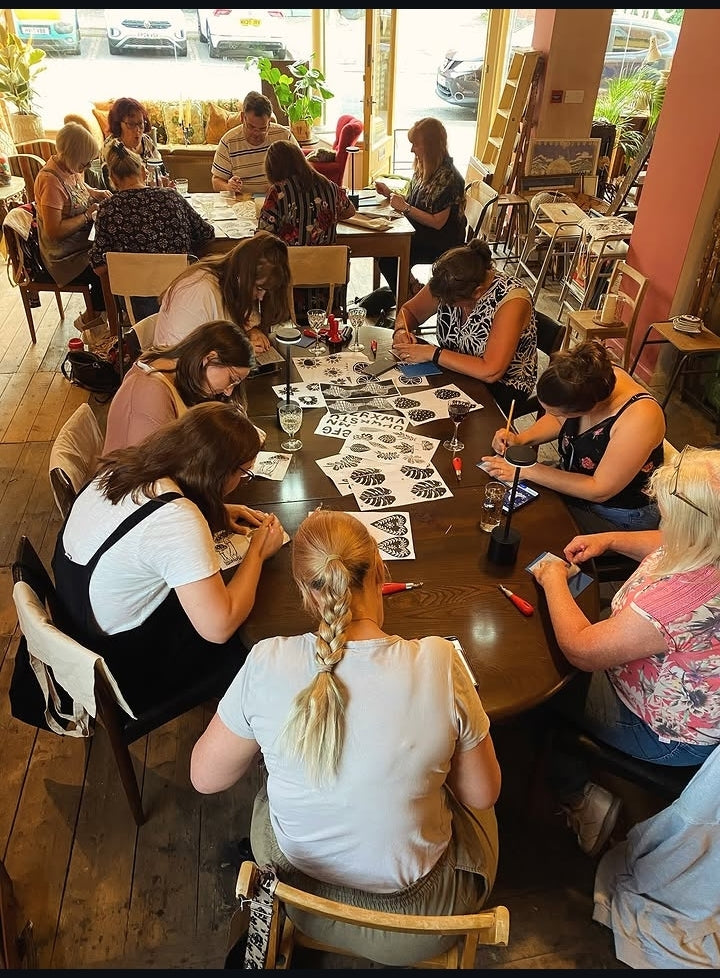 people visiting a workshop, working around a table. 